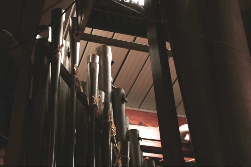 The huge pipes of a grand organ almost reach the roof of a room