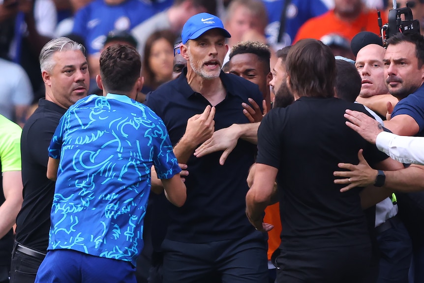 Chelsea coach Thomas Tuchel shouts at Tottenham coach Antonio Conte after a Premier League match as people hold them back.