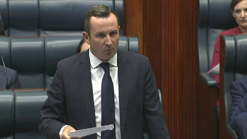 Premier Mark McGowan stands speaking in the Legislative Assembly wearing a suit and tie.