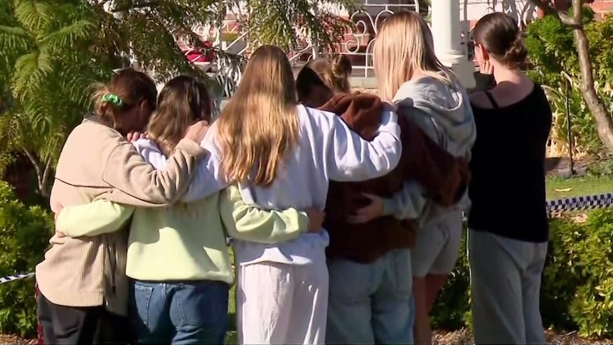a group of young women hug and pay tribute outside the house where two women were killed at floreat in wa