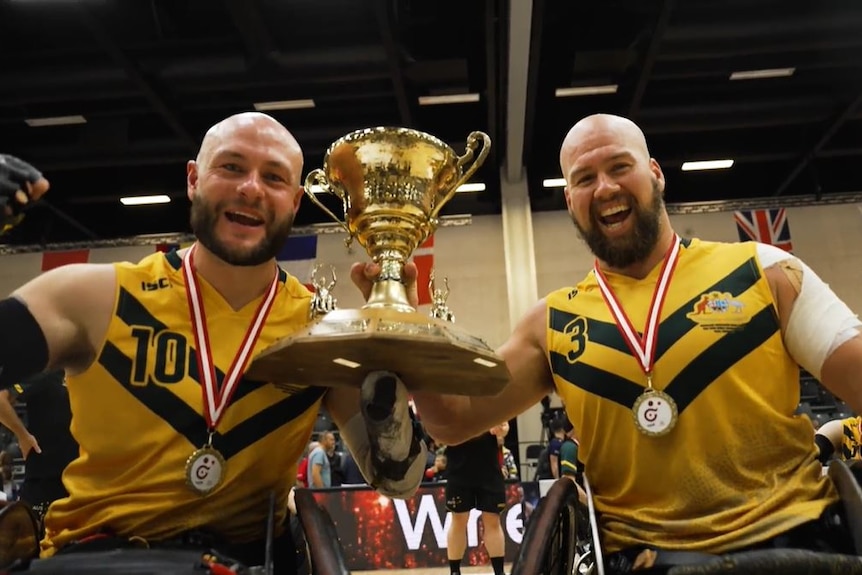 Australian Steelers Chris Bond and Ryley Batt with the trophy after winning the wheelchair rugby world championship final.