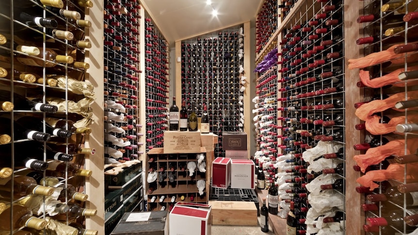 A small room with thousands of bottles of wine in it.