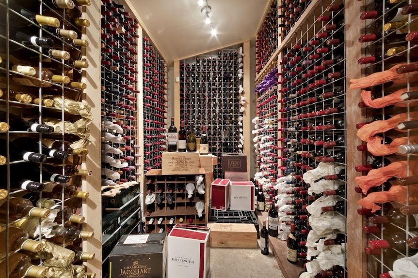 A small room with thousands of bottles of wine in it.