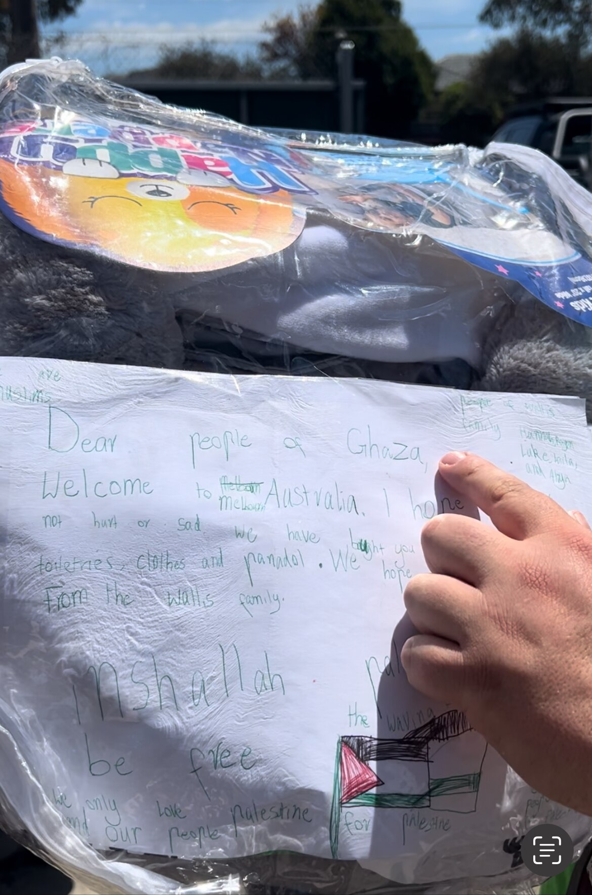 Hand written letter to Gazan kids. Adam's hand pointed to it.
