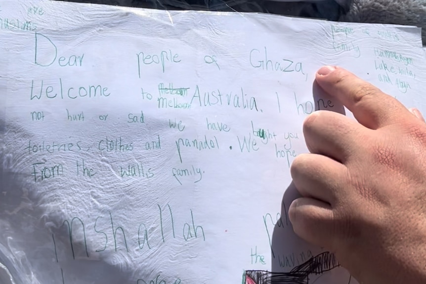 Hand written letter to Gazan kids. Adam's hand pointed to it.