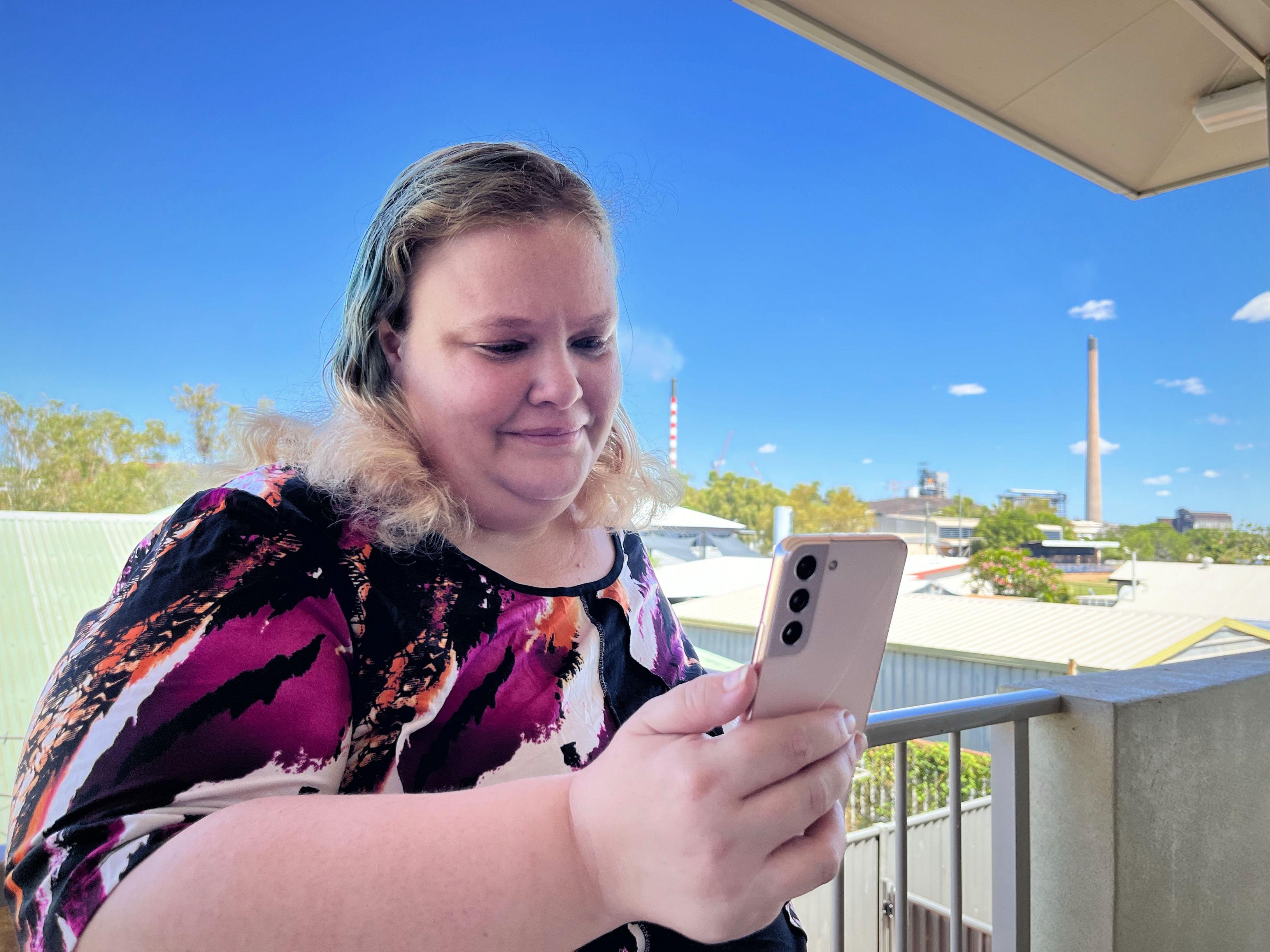 A woman video calls family on her mobile.