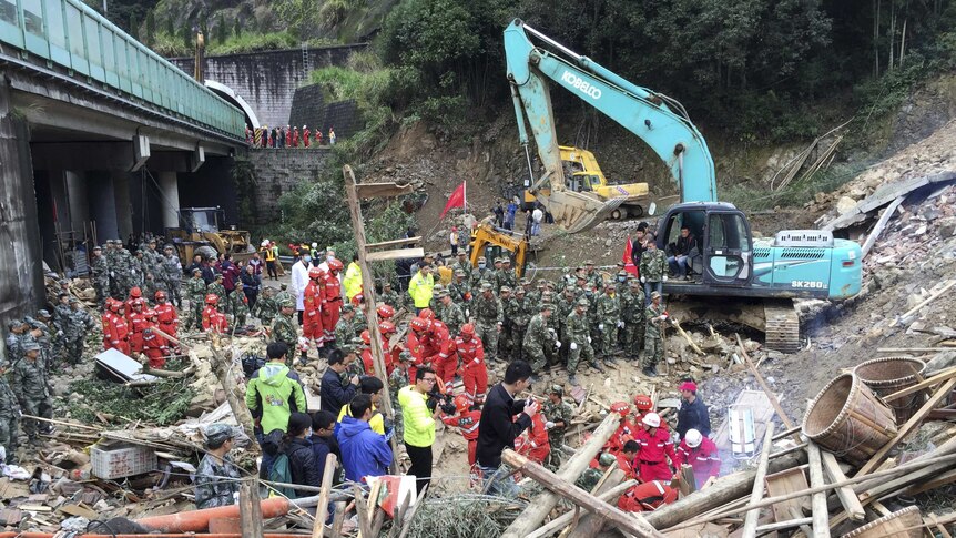 Rescuers search for survivors among debris at the site of a landslide.