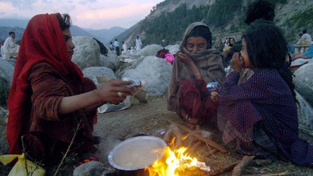 Pakistanis left homeless by the earthquake prepare food at a camp.