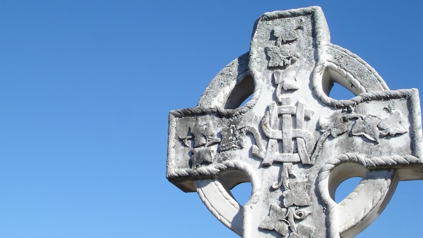 Detail of an old headstone against the sky