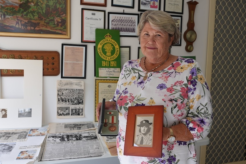 Photo of a woman holding a picture.