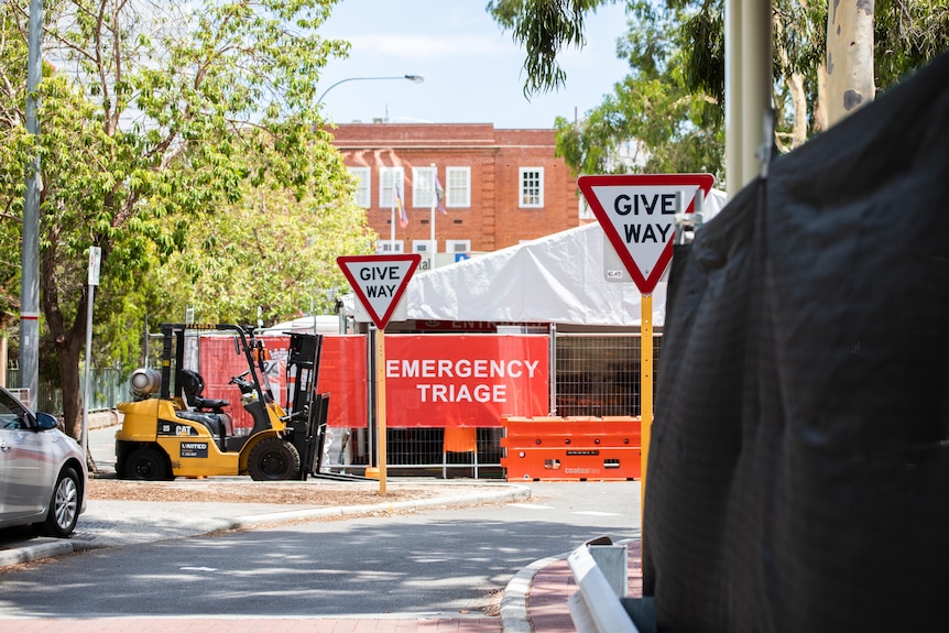 A tent behind a fence with a sign reading 'Emergency Triage'.