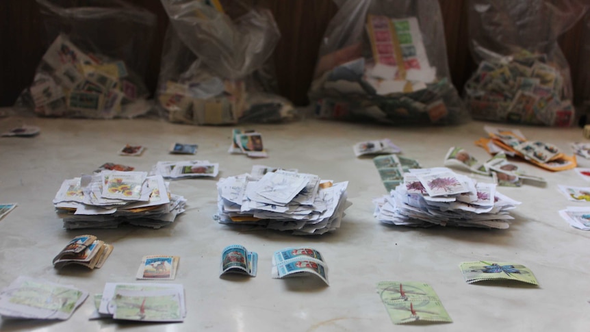 Used stamps in organised piles on a table top.