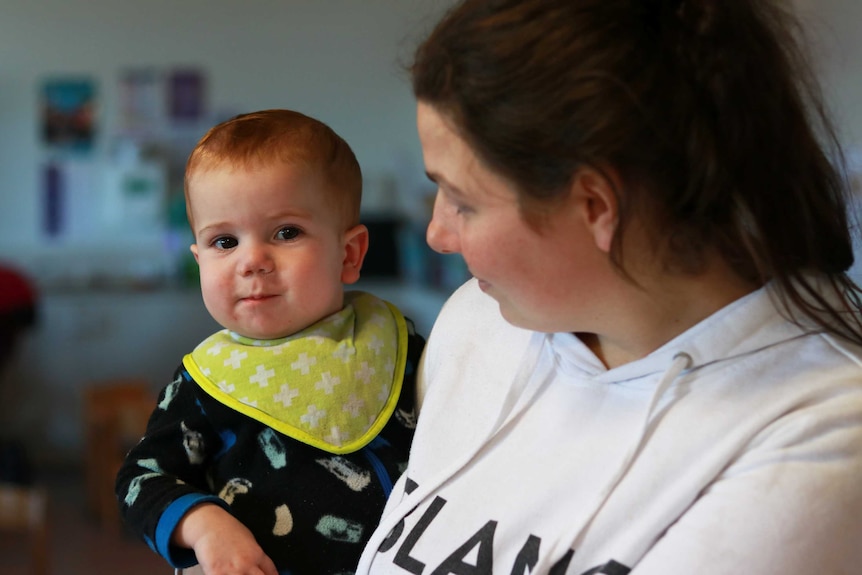 A mother holds her 7-month old baby