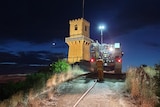  A truck parked in front of a tower at night