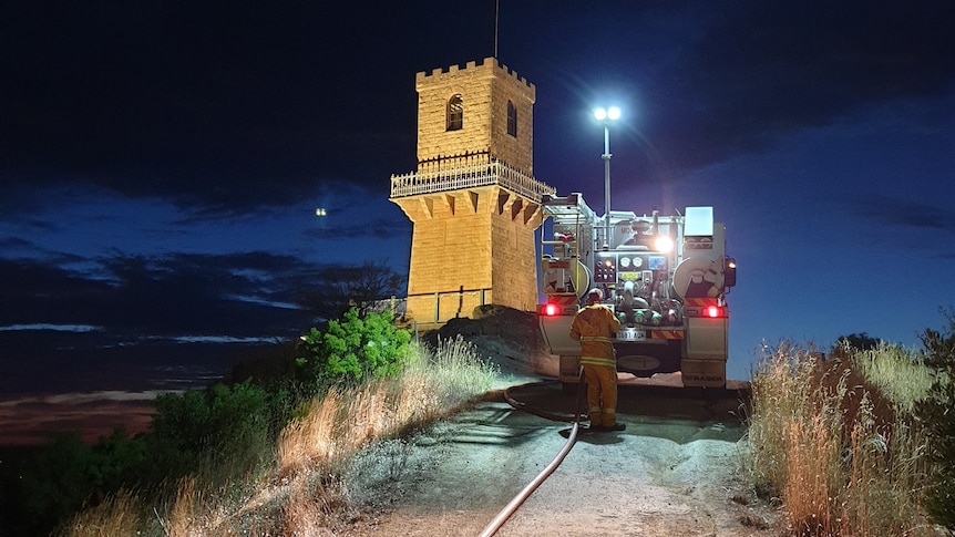  A truck parked in front of a tower at night