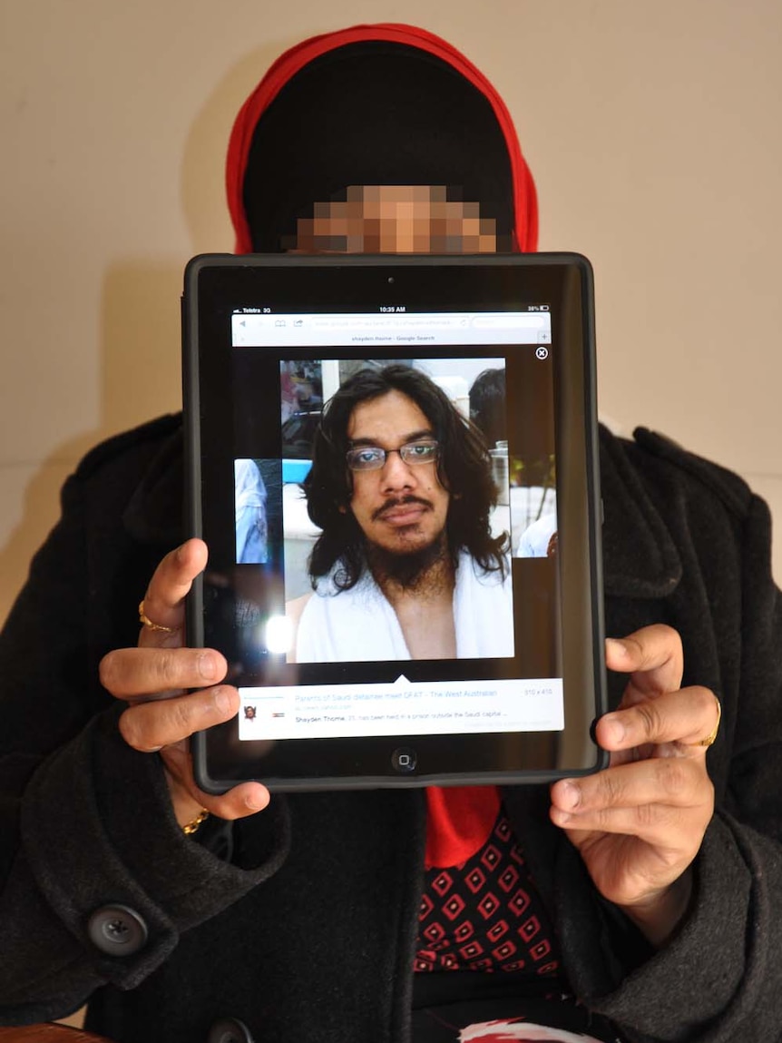 Shayden Thorne's mother holds up a photo of her son