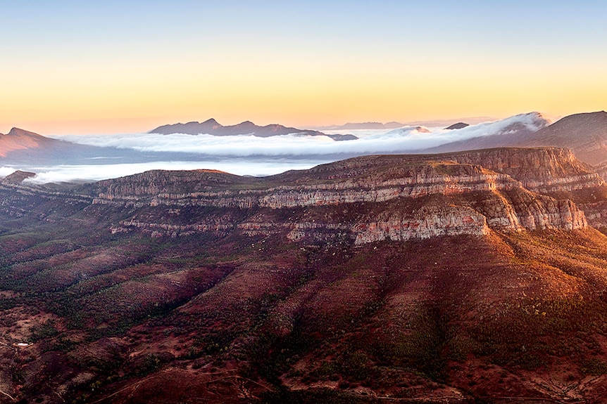 An aerial view of Wilpena Pound covered in mist.