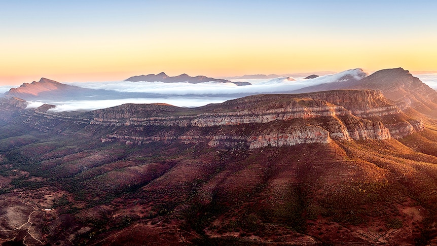 An aerial view of Wilpena Pound covered in mist.