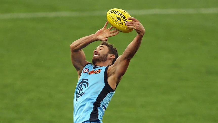 Carlton's Andrew Walker attempts a mark in front of Port Adelaide's Michael Pettigrew.