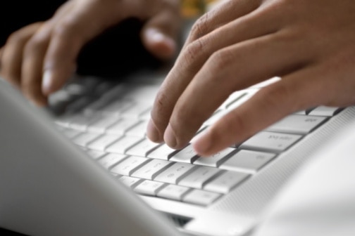 Close-up of a person using a laptop. (Thinkstock: Medioimages/Photodisc)