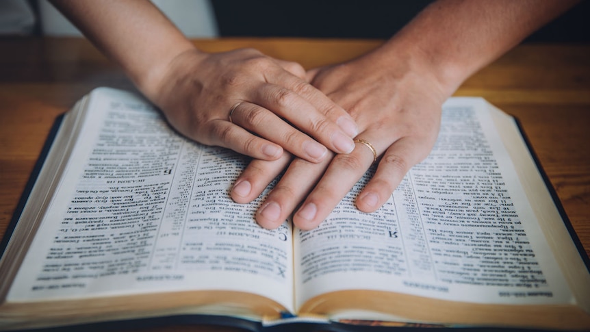 A woman praying over a bible