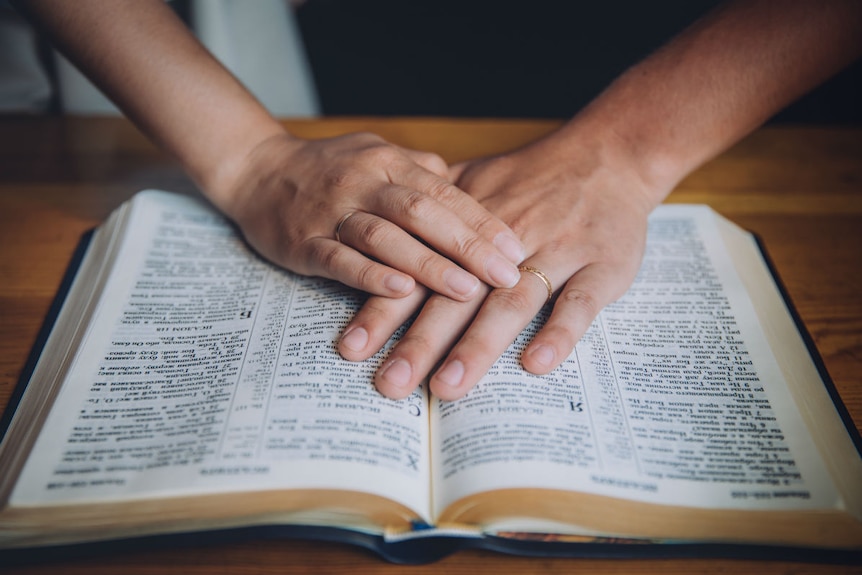 A woman praying over a bible