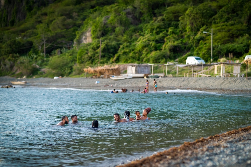 A group of people swimming in beautiful blue water 