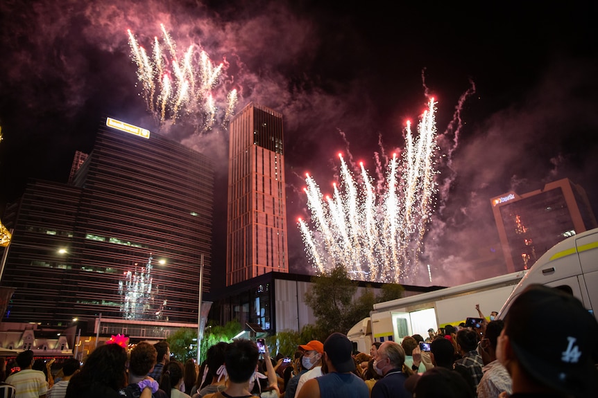 Coloured fireworks explode over Perth's CBD.