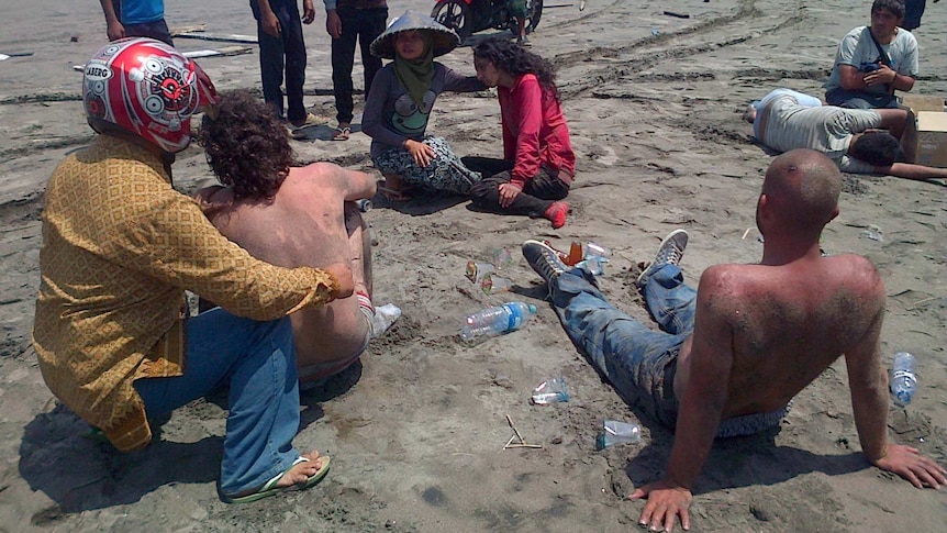 Locals help asylum seekers who survived the boat capsizing off the coast of Indonesia.