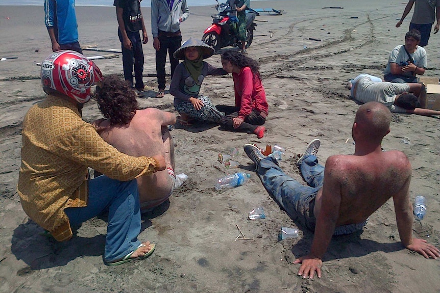 Locals help asylum seekers who survived the boat capsizing off the coast of Indonesia.