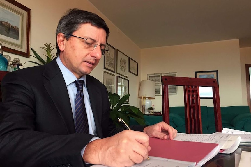 Florence's chief prosecutor Guiseppe Creazzo sits writing at his desk