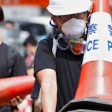 A man carrying a bunch of traffic cones