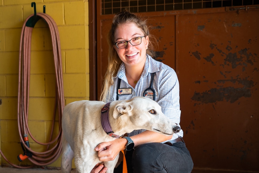 Veterinary surgeon Nickala Elin with a white-haired greyhound dog.