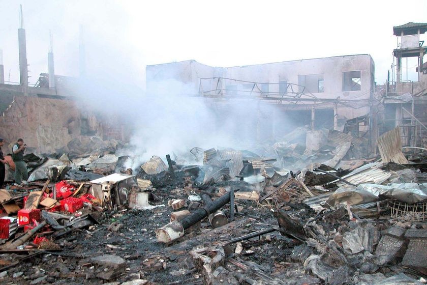 Smoke rises from the rubble of a building that was bombed