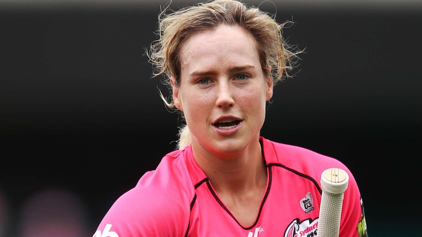 Ellyse Perry carries her bat, gloves and helmet off the field.