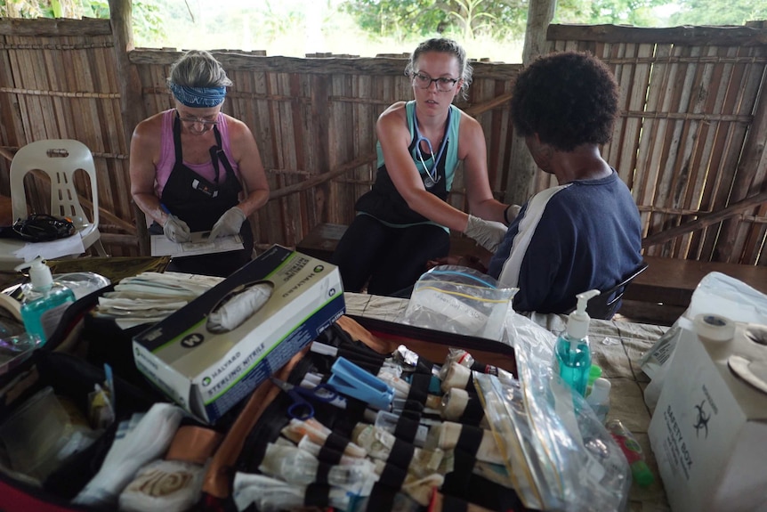 No Roads to Health volunteers Helen Fountain and Cailley Orrock treat a patient at the clinic.