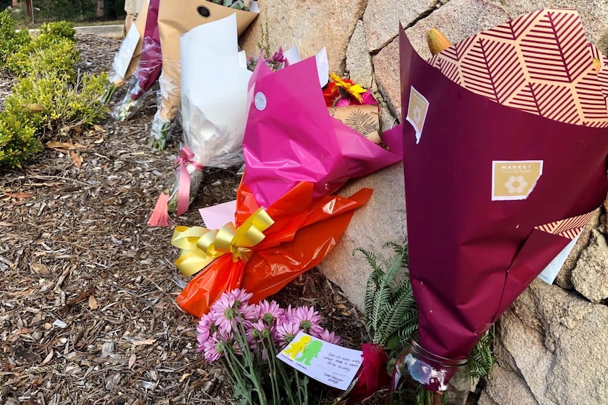 Floral tributes left on the driveway of the house where the bodies of Loris and Franco Puglia were found.