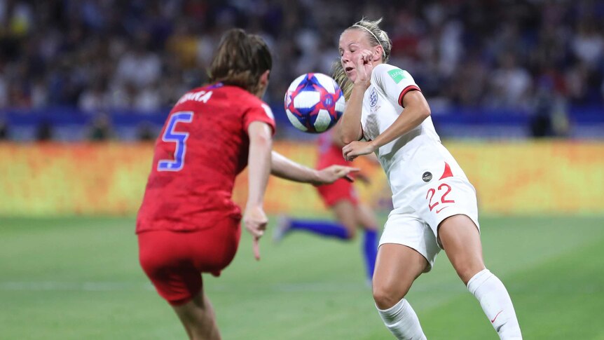 Kelley O'Hara kicks the ball in the direction of Beth Mead, who closes her eyes.