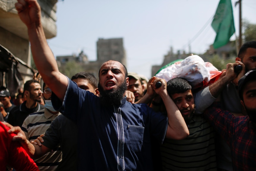 Mourners carry the body of a Gazan man slain in Israeli airstrikes.