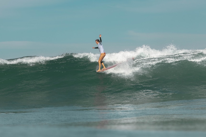 woman riding a wave on a surfboard