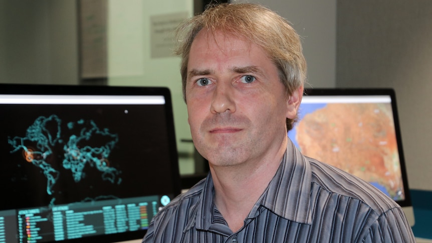 Head and shoulders pic of cyber security expert Associate Professor Paul Haskell-Dowland with computer screens in the background