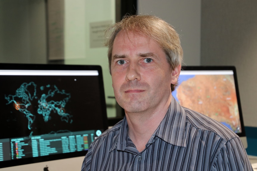 Head and shoulders pic of cyber security expert Associate Professor Paul Haskell-Dowland with computer screens in the background