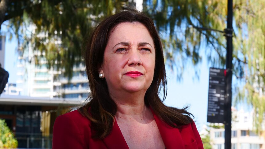 Annastacia Palaszczuk with trees behind her and sun on her face.