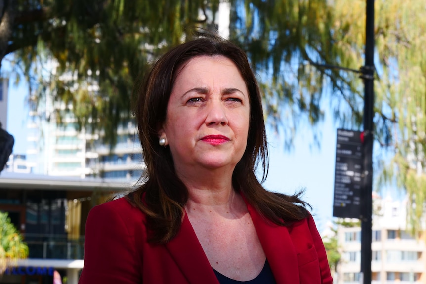 Annastacia Palaszczuk with trees behind her and sun on her face.