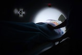 A woman passes through an MRI scan.