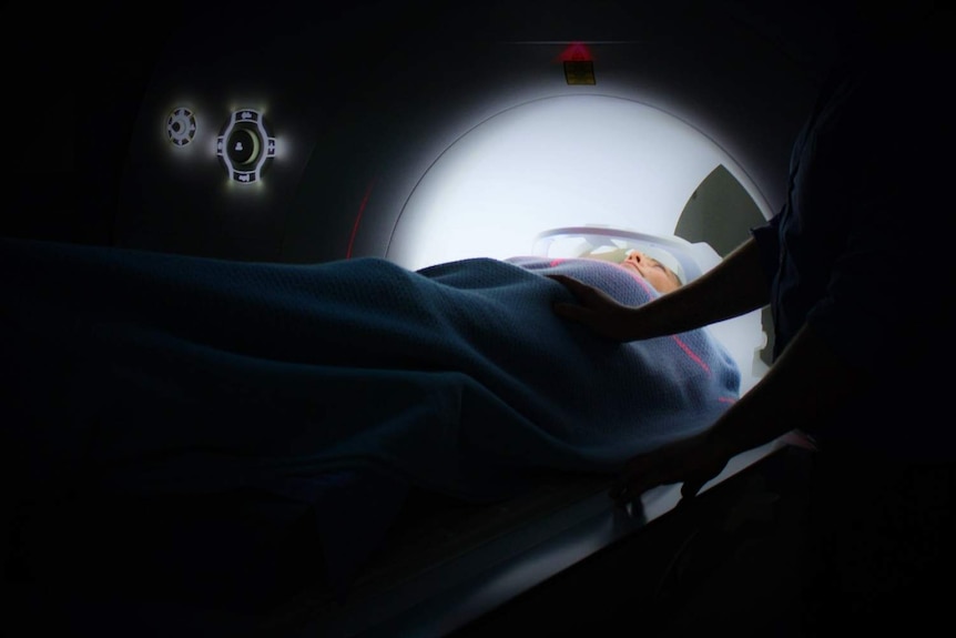 A woman passes through an MRI scan.