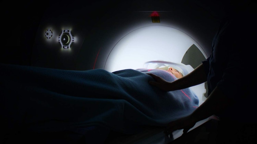 A woman passes through an MRI scan.