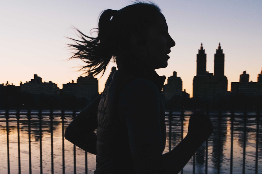 A woman running at sunrise.