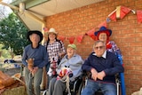 A group of older men and women with toy horses, at a nursing home, Coonamble western New South Wales