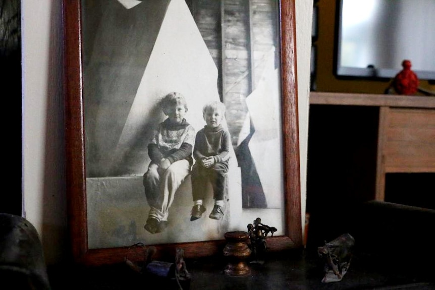 A photo of a picture of Barbara McKay's sons sitting on a sculpture in their father's studio.
